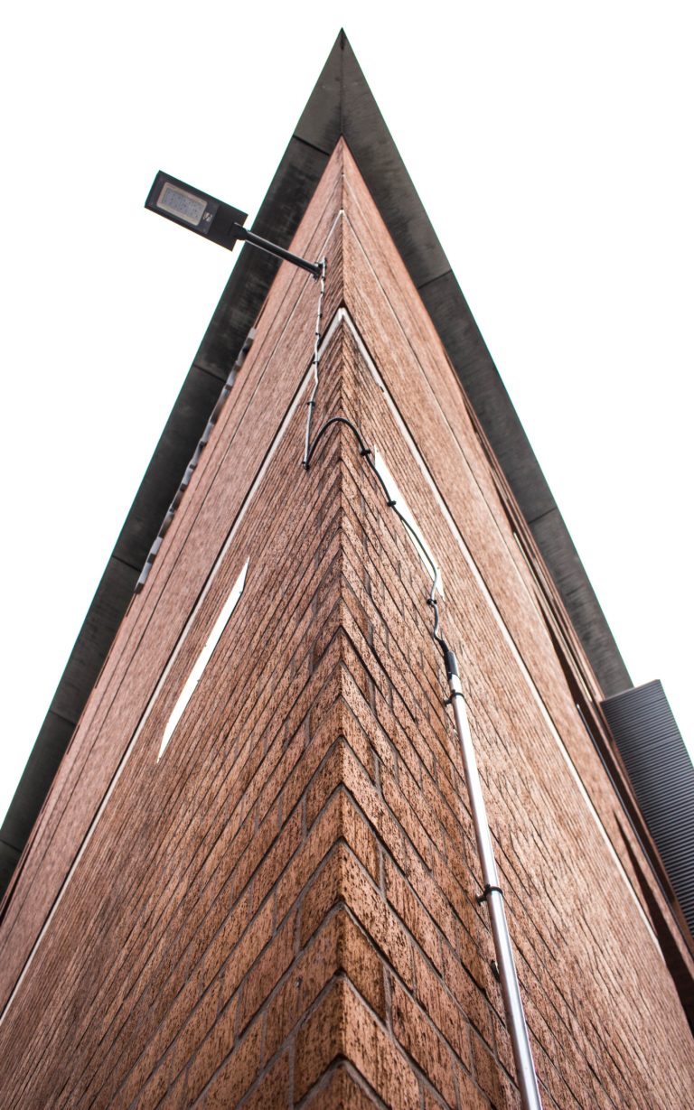 A corner of a narrow brick building.