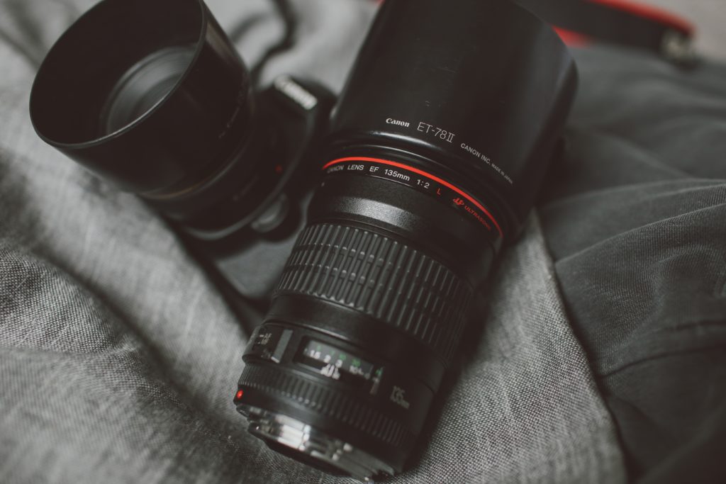 image of two canon prime lenses with their lens hoods on showing to explain the purpose of camera lens hoods